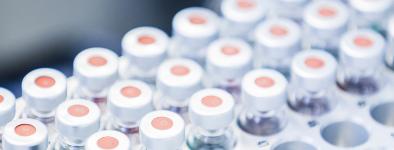 Header image students red gears campus north Students in summer on north campus, red gears in background.